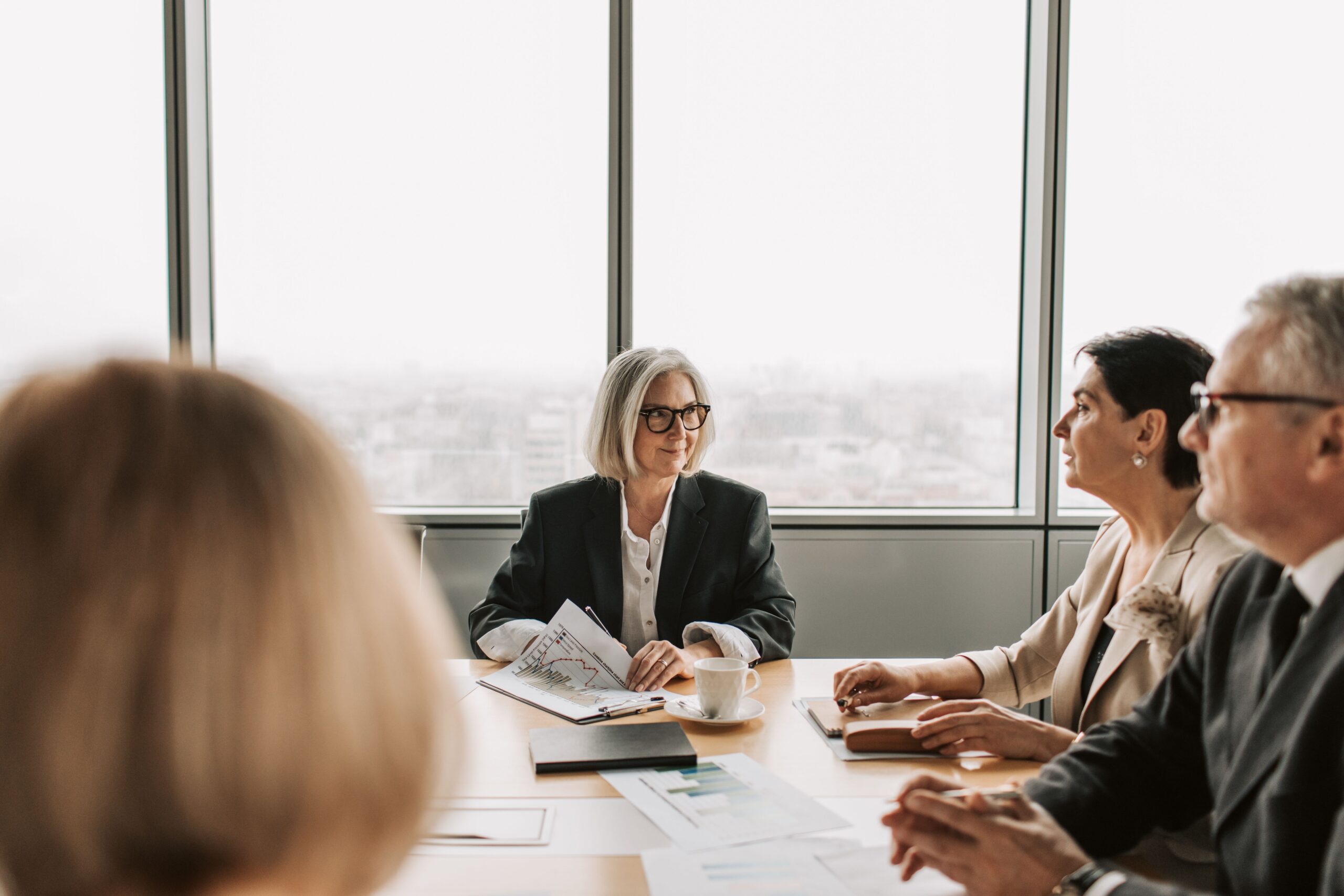 Business professionals seated around a conference table during a corporate meeting.